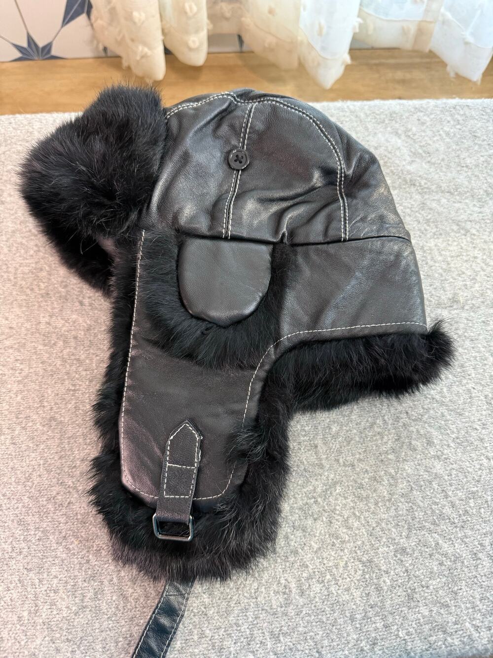 Black leather-feel and real fur trapper hat with ear flaps and quilted lining